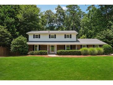 Charming two-story home boasts a brick facade, manicured lawn, and lush landscaping at 4984 Wickford Way, Atlanta, GA 30338