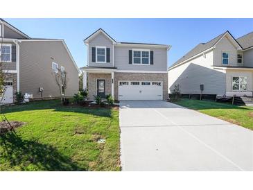 Charming two-story home with a two-car garage and well-maintained lawn at 11847 Rizvan Pl, Covington, GA 30014