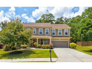 Charming two-story home with lush green lawn and mature trees in a desirable neighborhood at 3876 Thackary Dr, Powder Springs, GA 30127