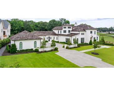 Beautiful white stucco home with a lush green lawn and manicured landscaping at 1640 Kenai Rd, Kennesaw, GA 30152