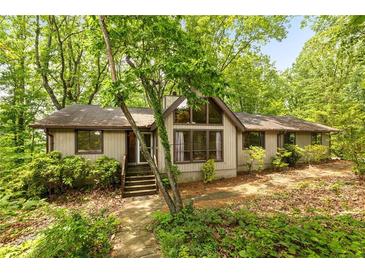 Charming home featuring a gable roof and lots of windows surrounded by mature trees at 1832 Tree Top Ct, Marietta, GA 30062