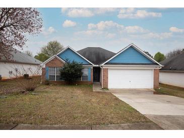 Charming single-Gathering home with blue trim, brick accents, and an attached two-car garage at 4931 Wilkins Station Dr, Decatur, GA 30035