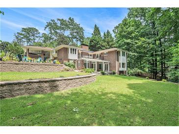 Expansive brick home with terraced yard, beautiful landscaping, and mature trees at 1620 Stonecliff Dr, Decatur, GA 30033