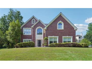 Beautiful brick two-story home with well-manicured lawn and mature trees on a sunny day at 2268 Orleans Ave, Marietta, GA 30062