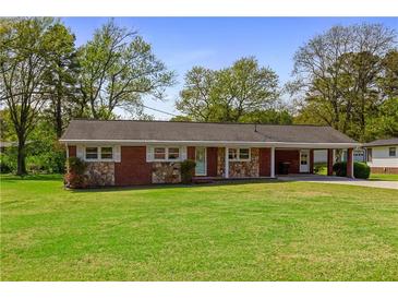 Charming brick and stone home featuring a well-manicured lawn and covered carport at 3031 Walker Dr, Marietta, GA 30062