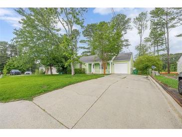 Charming single-story home with a long driveway, attached garage, and lush front lawn at 1249 Riva Ridge Dr, Norcross, GA 30093