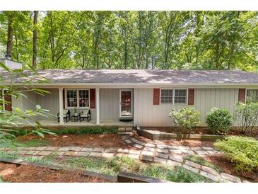 Charming single-story home with a covered front porch and natural stone walkway amid wooded surroundings at 2880 Foothill Trl, Marietta, GA 30066