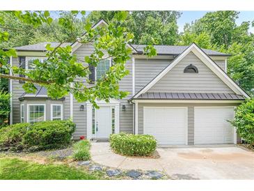 Charming gray two-story home featuring a two-car garage and meticulously maintained landscaping at 4959 Abbotts Glen, Acworth, GA 30101