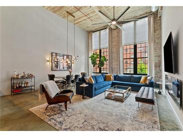 Bright, open living room with high ceilings, exposed brick, large windows, and stylish modern decor at 170 Boulevard Se # E120, Atlanta, GA 30312