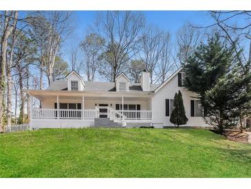 Charming white two-story home featuring a welcoming front porch and well-manicured lawn at 4100 Summer Wood Dr, Snellville, GA 30039