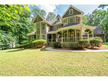 Charming two-story home with lush lawn and inviting wraparound porch, perfect for enjoying peaceful outdoor living at 220 Mars Hill Rd, Powder Springs, GA 30127