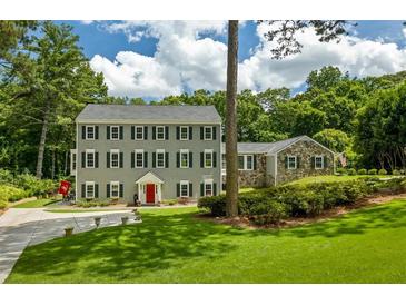 Charming traditional home with a symmetrical facade, lush lawn, and a welcoming red front door at 555 Valley Hall Dr, Atlanta, GA 30350