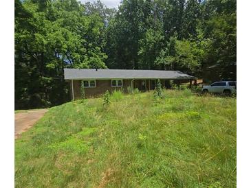 Quaint brick home on a lush, overgrown lot, offering privacy and potential at 5533 Glore Sw Dr, Mableton, GA 30126