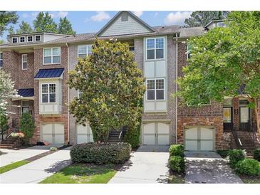 Charming townhome with a brick facade, attached garage, and well-maintained landscaping at 1986 Cobblestone Ne Cir, Atlanta, GA 30319