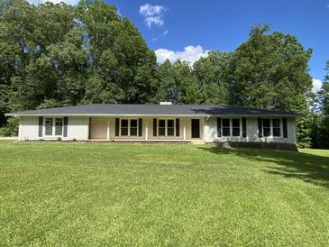 Charming single-story home with a well-manicured lawn and mature trees providing a peaceful and inviting setting at 3975 N Sharon Church N Rd, Loganville, GA 30052