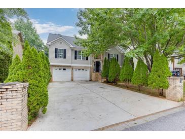 Charming two-story home with a two-car garage, well-maintained lawn, and mature trees at 571 Oak Vista Ct, Lawrenceville, GA 30044