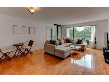 Bright living room featuring a large sectional sofa and hardwood floors, perfect for relaxing and entertaining at 3481 Lakeside Ne Dr # 902, Atlanta, GA 30326
