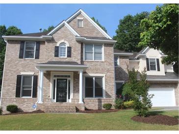Charming two-story brick home with a well-manicured lawn, black shutters, and a bright, two-car garage at 733 Miller Run Run, Atlanta, GA 30349