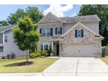 Charming two-story brick home with well-maintained landscaping and a two-car garage at 2099 Lakeview Bend Way, Buford, GA 30519