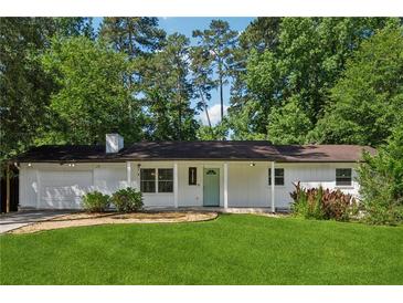 Charming one-story home with a well-manicured lawn and light blue front door at 3123 Deshong Dr, Stone Mountain, GA 30087