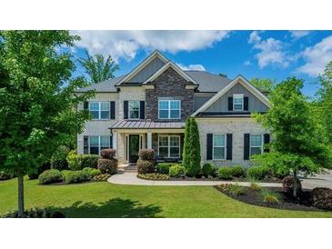 Beautiful two-story home featuring a well-manicured lawn and appealing brick and stone facade at 3755 Valleyway Rd, Cumming, GA 30040