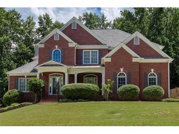 Charming two-story red brick home featuring a well-manicured lawn and attractive landscaping at 2625 Morningside Nw Trl, Kennesaw, GA 30144