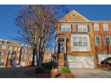 Charming brick townhome featuring a manicured lawn, attached garage, and classic architectural details at 401 Iona Abbey Ct # 6, Smyrna, GA 30082