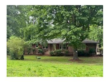 Traditional brick home with a mature tree in the front yard providing shade and curb appeal at 4485 Canary Ct, Lithia Springs, GA 30122