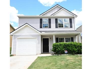 Charming two-story home with a well-manicured lawn, an attached garage, and inviting front entrance at 515 Brady Dr, Villa Rica, GA 30180