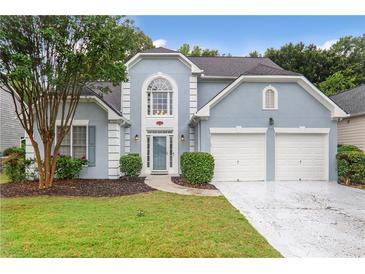 Charming light blue two-story home featuring a two-car garage and manicured landscaping at 845 Melbourne Trl, Alpharetta, GA 30009