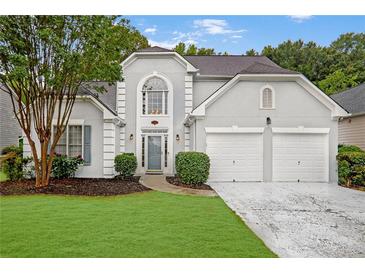 Charming two-story home featuring well-manicured lawn, mature trees, and an attached two-car garage at 845 Melbourne Trl, Alpharetta, GA 30009
