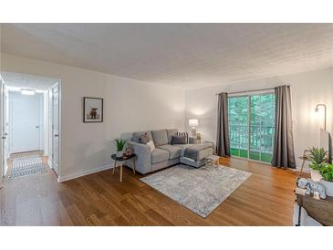 Bright living room with hardwood floors, neutral colors, and a sliding glass door to the outside at 3135 Seven Pines Ct # 8, Atlanta, GA 30339