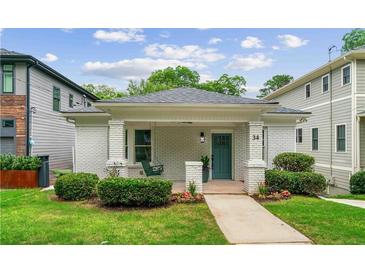 Charming brick home featuring a covered front porch and a well-manicured lawn at 34 Montgomery Se St, Atlanta, GA 30317