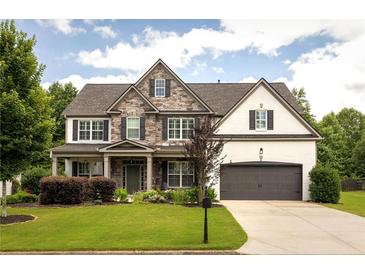 Charming two-story home featuring a stone and brick facade, well-manicured lawn, and an attached two-car garage at 374 Heritage, Woodstock, GA 30188