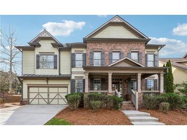 Charming two-story home with brick and siding, featuring a covered porch and well-maintained landscaping at 4492 Arbor Crest Ct, Suwanee, GA 30024