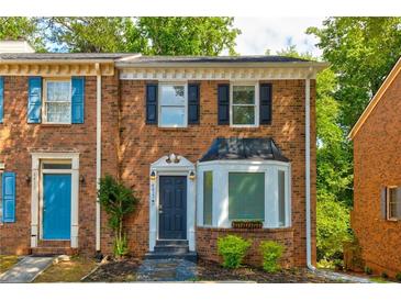 Charming brick townhome featuring classic architectural details and a beautifully landscaped front yard at 4417 Village Square Ln, Stone Mountain, GA 30083