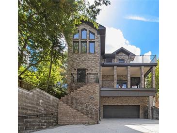 Stunning elevation of brick home with multi-level decks and grand staircase, complemented by a convenient garage at 1260 Monroe Ne Dr, Atlanta, GA 30306