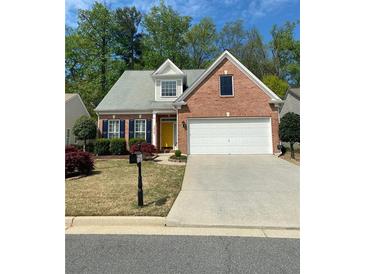 Charming single-Gathering home featuring a brick facade, two-car garage, manicured lawn, and a vibrant yellow front door at 3427 Hampreston Nw Way, Kennesaw, GA 30144