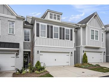 Charming townhome featuring a two-car garage, modern design elements, and well-maintained landscaping at 1247 Winterhaven Dr, Cumming, GA 30041
