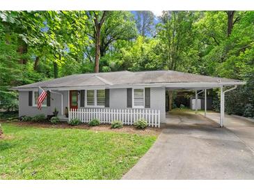 Charming single-story home featuring a classic brick facade, white picket fence, and an inviting carport at 269 Terrydale Se Dr, Marietta, GA 30067