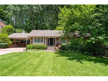 Charming single-story home with a well-manicured lawn and lush landscaping at 2917 Rockingham Nw Dr, Atlanta, GA 30327