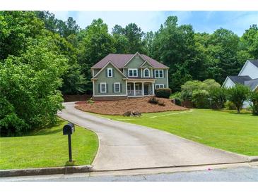 Gorgeous two-story home with a welcoming porch, mature trees, and a long driveway, offering serenity and privacy at 5741 Stonekirk Walk Northwest, Acworth, GA 30101