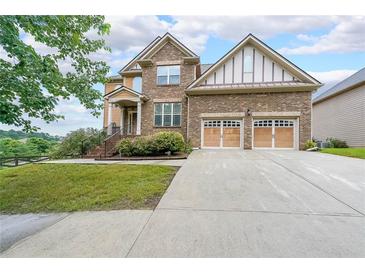 Two-story home with brick, a well-manicured lawn and a two car garage at 1057 Cotton Oak Dr, Lawrenceville, GA 30045