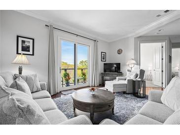 Inviting living room featuring plush seating, a cozy rug, and balcony access for natural light and fresh air at 326 Roswell Se St # 706, Marietta, GA 30060