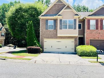 Charming townhome with brick facade, two-car garage and well-manicured landscaping at 2691 Pointcrest Way, Grayson, GA 30017