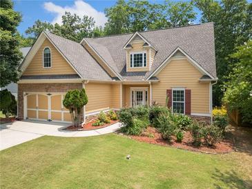 Inviting home with a well-manicured lawn, stone accents, and a two-car garage on a sunny day at 9996 Village South Dr, Douglasville, GA 30135