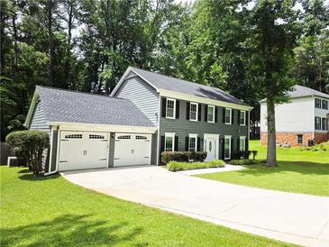Charming two-story home with a two-car garage and well-manicured lawn and mature trees at 3123 Westbrook Trce, Lawrenceville, GA 30044
