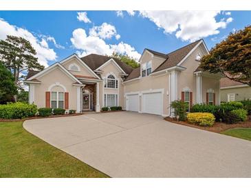 Charming two-story home with a well-manicured lawn, three-car garage, and inviting curb appeal at 9634 Coastal Pointe Dr, Villa Rica, GA 30180