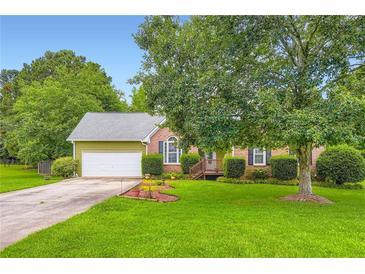Charming single-Gathering home with a lush green lawn, mature trees, and well-maintained landscaping at 180 Moseley Crossing Dr, Stockbridge, GA 30281
