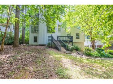 View of home featuring mature trees, a deck, stairs, and fresh landscaping at 1282 Shiloh Trail E, Kennesaw, GA 30144